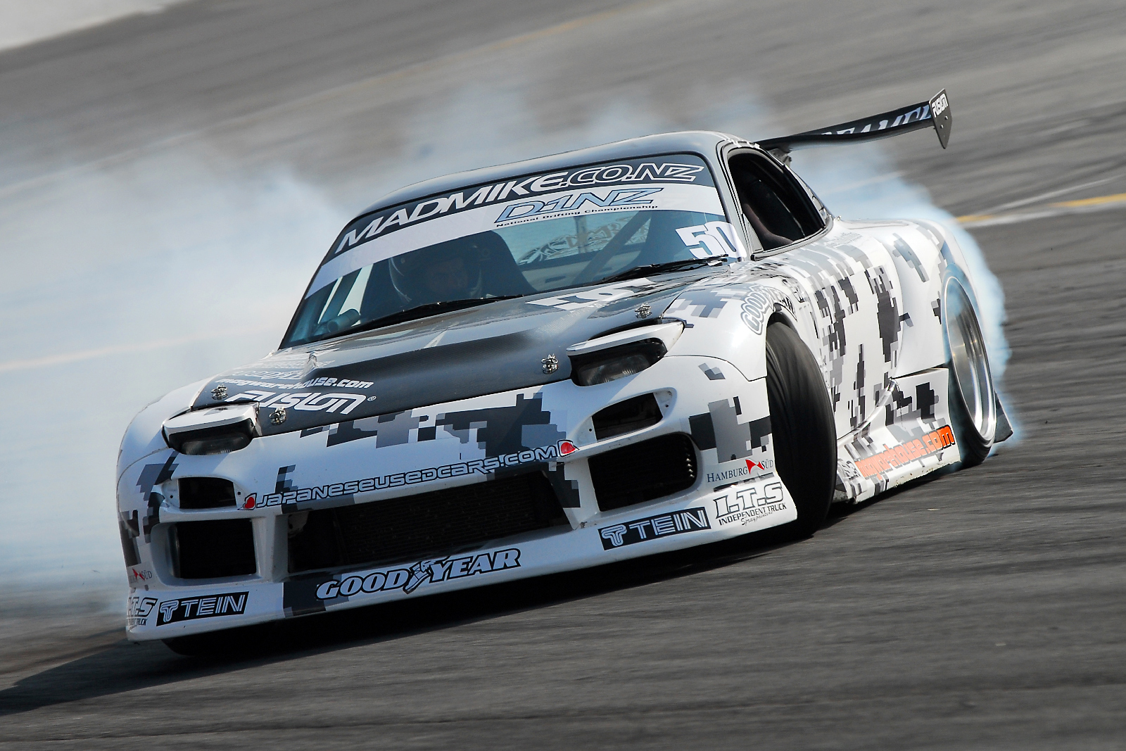 Mad Mike Whiddett four-rotor Mazda RX-7 FD spitting flame from the exhaust mid-drift on the Goodwood Festival of Speed hillclimb