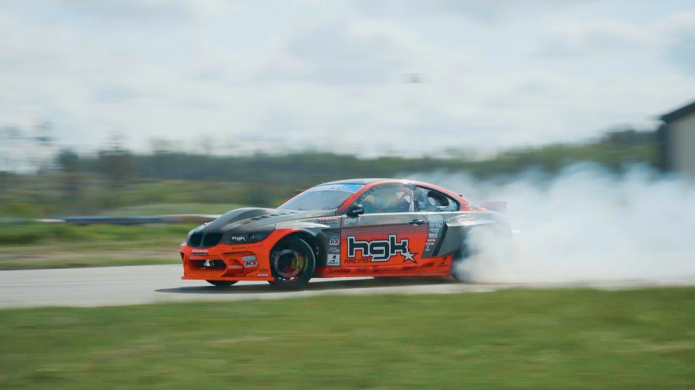 Kristaps Blušs at the wheel of the carbon-bodied HGK BMW E92 Eurofighter mid-slide